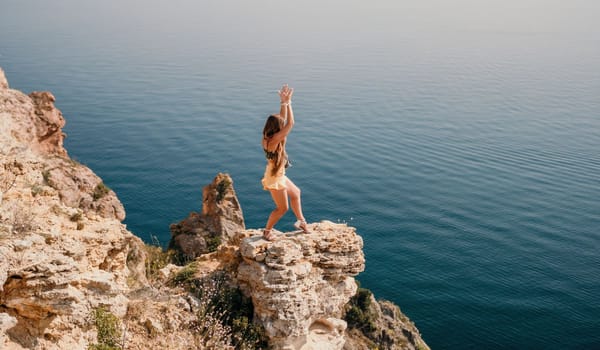 Woman travel sea. Happy tourist taking picture outdoors for memories. Woman traveler looks at the edge of the cliff on the sea bay of mountains, sharing travel adventure journey.