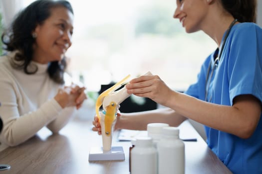 Portrait of a female doctor talking to an elderly patient about osteoarthritis