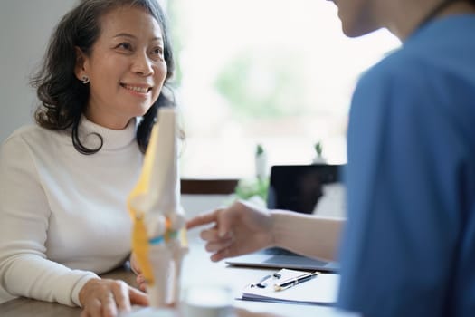 Portrait of a female doctor talking to an elderly patient about osteoarthritis