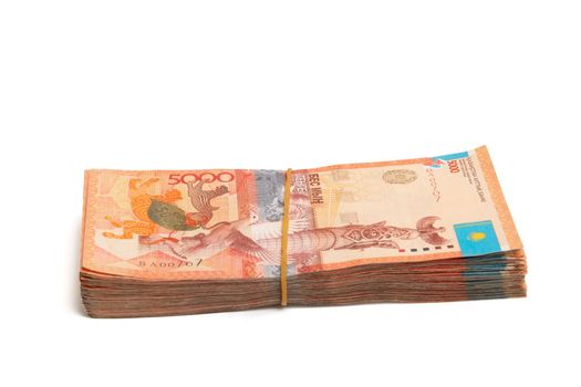 Side view of Bundle of Kazakhstan banknotes of 5000 tenge tied with an elastic band, isolated on white.