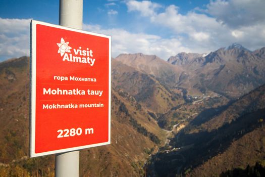On the top of Mount Mokhnatka next to Medeu with a view of the Chimbulak ski resort in summer. Domestic tourism in Kazakhstan. Almaty, Kazakhstan - September 05, 2022