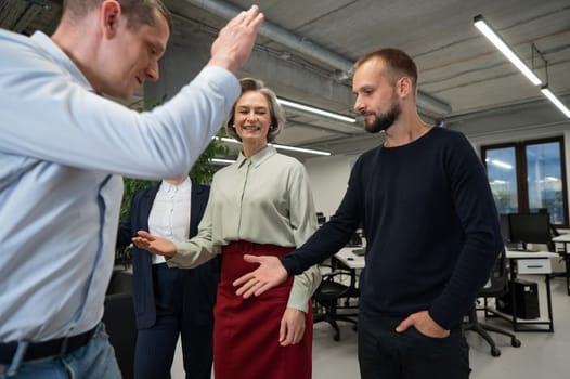 Four co-workers give a high five in the office