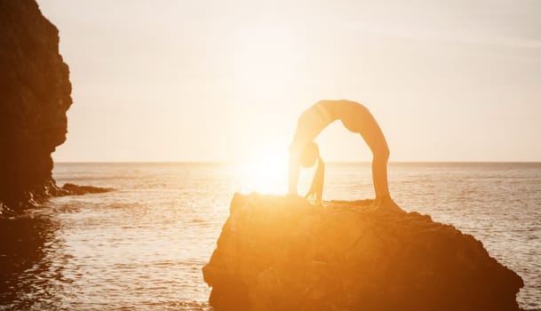 Young woman with black hair, fitness instructor in pink sports leggings and tops, doing pilates on yoga mat with magic pilates ring by the sea on the beach. Female fitness daily yoga concept