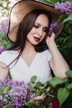 A fashionable girl with dark hair, a spring portrait in lilac tones in summer. Bright professional makeup