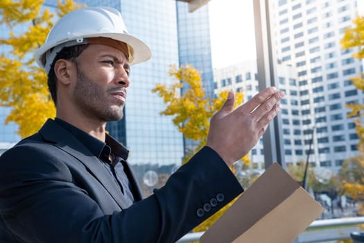 Experienced architect, constructor engineer in protective white helmet controls the object at the construction site for the renovation of buildings. Civil engineering concept. High quality photo