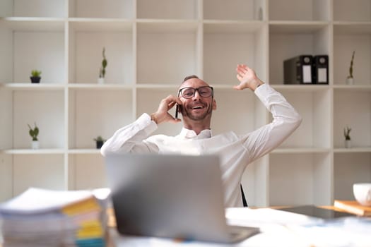 Businessman Making Phone Call Sitting At Office.