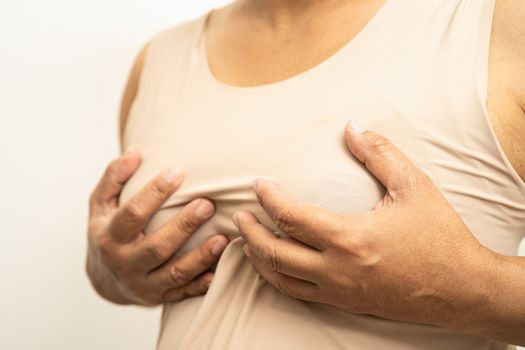 Asian woman patient checking and worry her breast, Breast Self Exam or BES, symbol of World Breast Cancer Day.