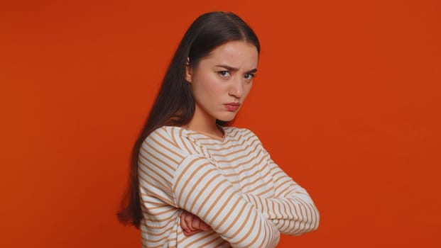 Dissatisfied pretty nervous woman asking reason of failure, expressing disbelief irritation, feeling bored, disappointed in result, bad news. Young adult girl isolated alone on red studio background