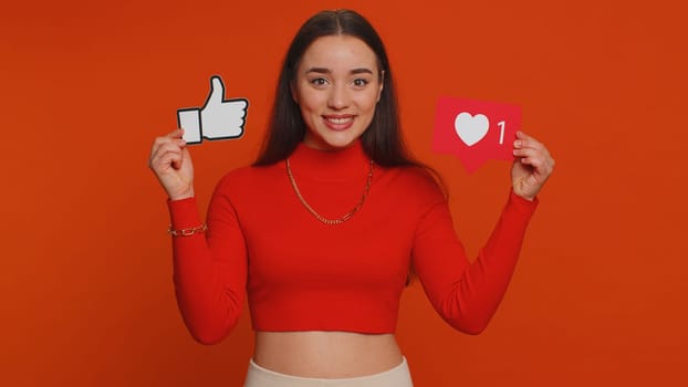 Like. Lovely woman raises inscription thumbs up banner thumbs up agrees with something, gives positive reply recommends advertisement likes good on social media. Young girl on red studio background