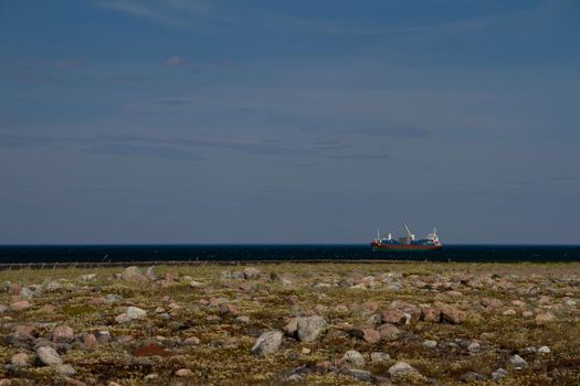 Fuel barge or tanker ship off the coast of Hudson Bay waiting to provide fuel for an arctic community, Nunavut, Canada