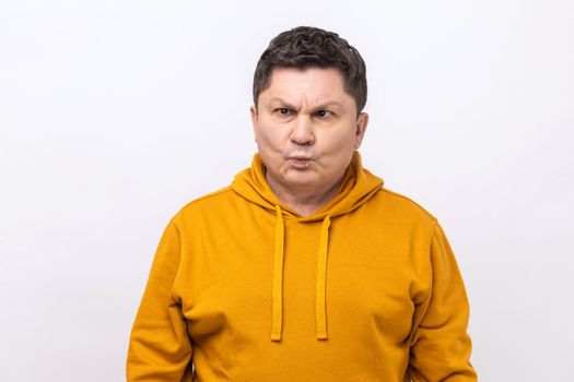 Funny amused middle aged man crossing his eyes looking crazy and stupid, fooling around, having fun, vision problems, wearing urban style hoodie. Indoor studio shot isolated on white background.
