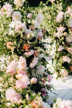 Wedding ceremony on the street on the green lawn.Decor with fresh flowers arches for the ceremony.