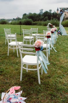 Wedding ceremony on the street on the green lawn.Decor with fresh flowers arches for the ceremony.