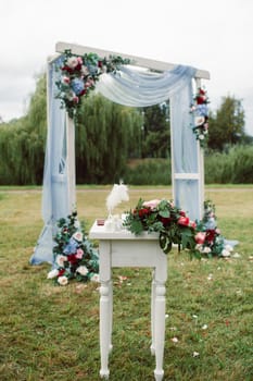 Wedding ceremony on the street on the green lawn.Decor with fresh flowers arches for the ceremony.