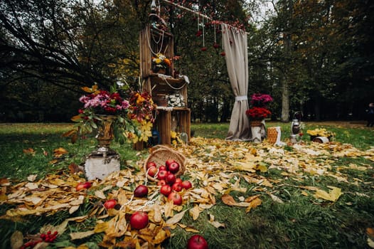 Autumn wedding ceremony on the street on the green lawn.Decor with arches of fresh flowers for the ceremony.