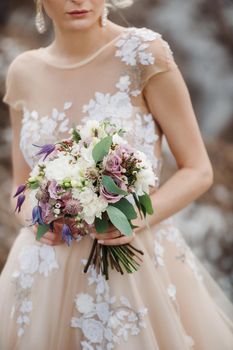 wedding bouquet with peonies in the hands of the bride under the veil.Morning of the bride.