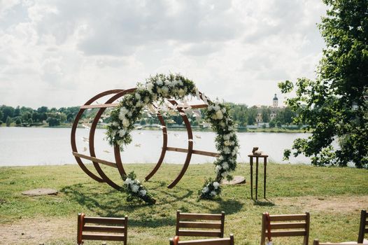 Wedding ceremony on the street on the green lawn.Decor with fresh flowers arches for the ceremony.