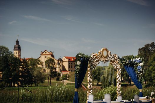 Wedding ceremony on the street on the green lawn.Decor with fresh flowers arches for the ceremony.