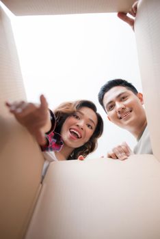 Young asian couple looking into the box
