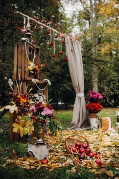 Autumn wedding ceremony on the street on the green lawn.Decor with arches of fresh flowers for the ceremony.