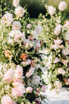 Wedding ceremony on the street on the green lawn.Decor with fresh flowers arches for the ceremony.