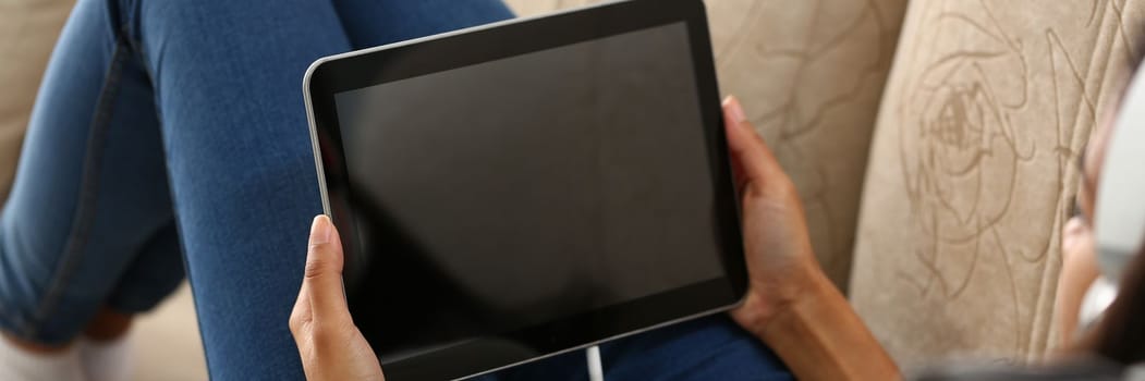 Woman using mobile app on digital tablet over shoulder view. Viewing information and communicating in social networks on Internet