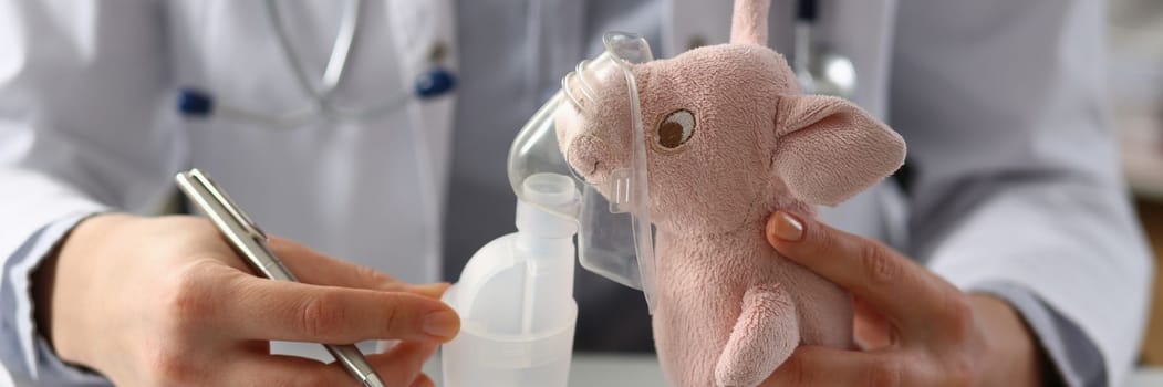 Doctor holds toy with oxygen mask in clinic. Nebulizer for children concept