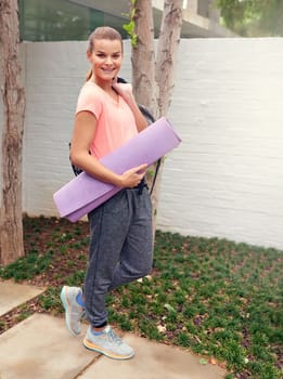 Cant wait to have another yoga session. a beautiful young woman carrying a yoga mat