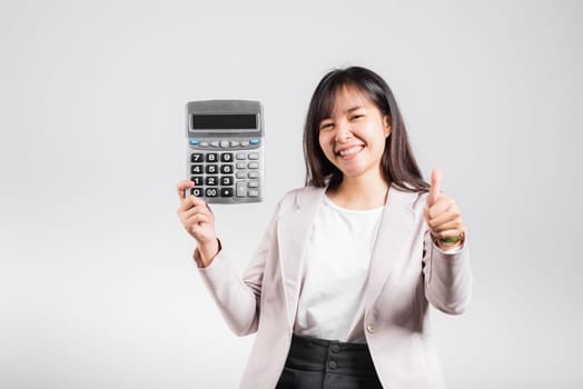 Tax day concept. Woman confident smiling holding electronic calculator and show thumb up for good gesture, excited happy Asian female isolated on white background, Account and finance counting income