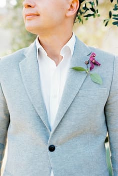 Groom in a gray jacket with a boutonniere. Cropped. High quality photo