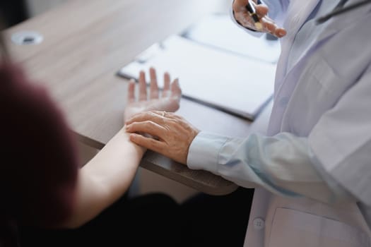 Portrait of a female doctor using a stethoscope to check the pulse of an elderly patient