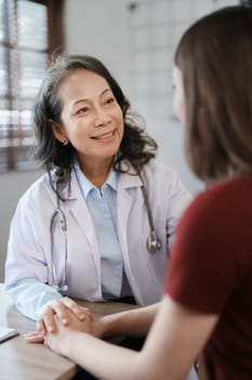 Portrait of a female doctor holding a patient's hand to encourage the fight against disease