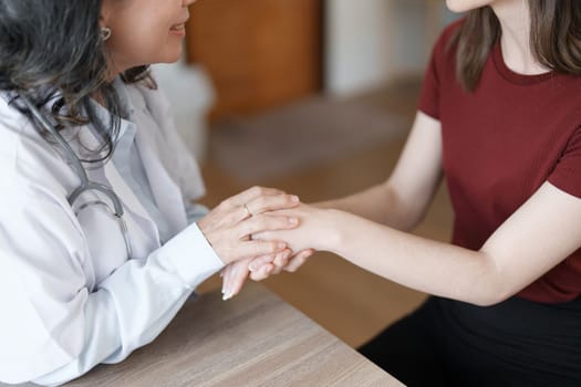 Portrait of a female doctor holding a patient's hand to encourage the fight against disease