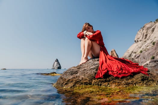 Woman travel sea. Happy tourist taking picture outdoors for memories. Woman traveler looks at the edge of the cliff on the sea bay of mountains, sharing travel adventure journey.