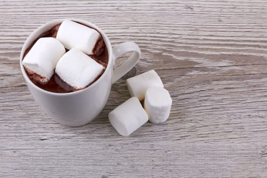 Cocoa with marshmallows on a wooden surface