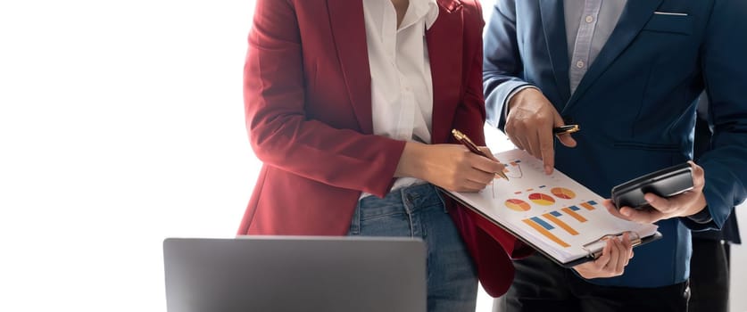 Group of confident business people point to graphs and charts to analyze market data, balance sheet, account, net profit to plan new sales strategies to increase production capacity.