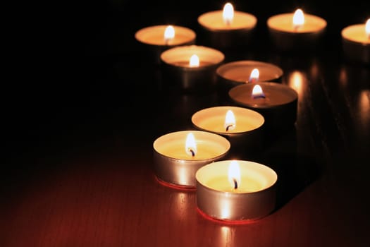 Set of lighting candles on dark background