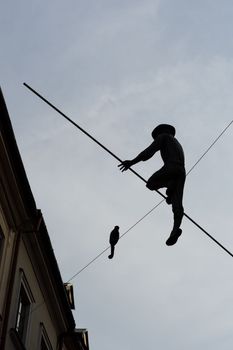 LUBLIN, POLAND - APRIL 30, 2021: Sculpture of a tightrope walker with a monkey in the old town of LublinHigh quality photo