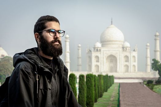 Young man with Taj Mahal back. Travel lifestyle in India, Asia. Adult solo travel.