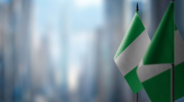 Small flags of the Nigeria on an abstract blurry background.