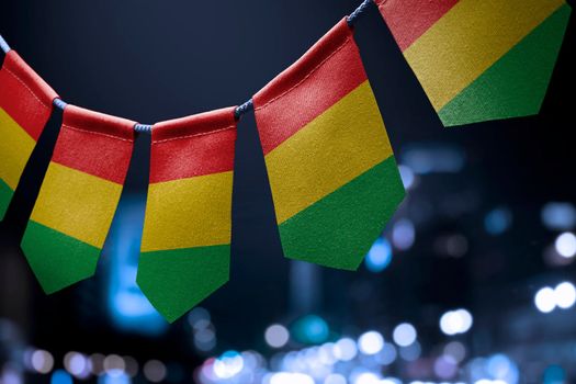 A garland of Guinea national flags on an abstract blurred background.