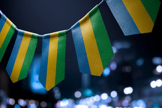 A garland of Gabon national flags on an abstract blurred background.