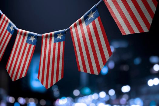 A garland of Liberia national flags on an abstract blurred background.