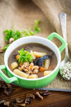 mushroom hot soup with beans in a bowl, on a rustic burlap tablecloth.