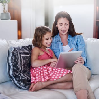 Bonding in the age of wireless tehnology. a mother and her daughter using wireless technology at home