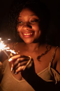 The inexhaustible joy of burning cold fires and the coming new year. Happiness and joy are drawn on the face of a dark-skinned girl.