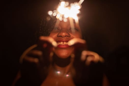 The inexhaustible joy of burning cold fires and the coming new year. Happiness and joy are drawn on the face of a dark-skinned girl.
