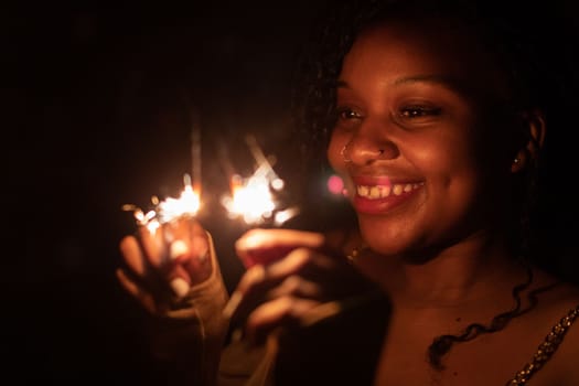 The inexhaustible joy of burning cold fires and the coming new year. Happiness and joy are drawn on the face of a dark-skinned girl.