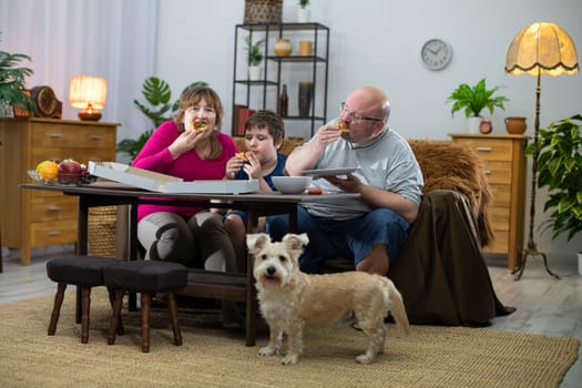 The dog didn't get any slice of pizza and is looking around for the next delivery. The family of her tasty pizza.