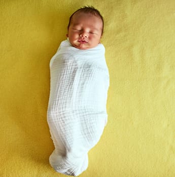 A little caterpillar. a tired little baby boy sleeping with his eyes closed on a bed at home